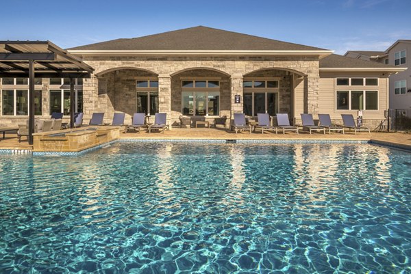 Sparkling outdoor pool with lounge chairs at Prose Magnolia Apartments, ideal for relaxation and leisure activities