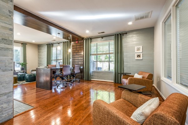 Modern lounge area with wooden flooring, stylish chairs, and large windows for natural light