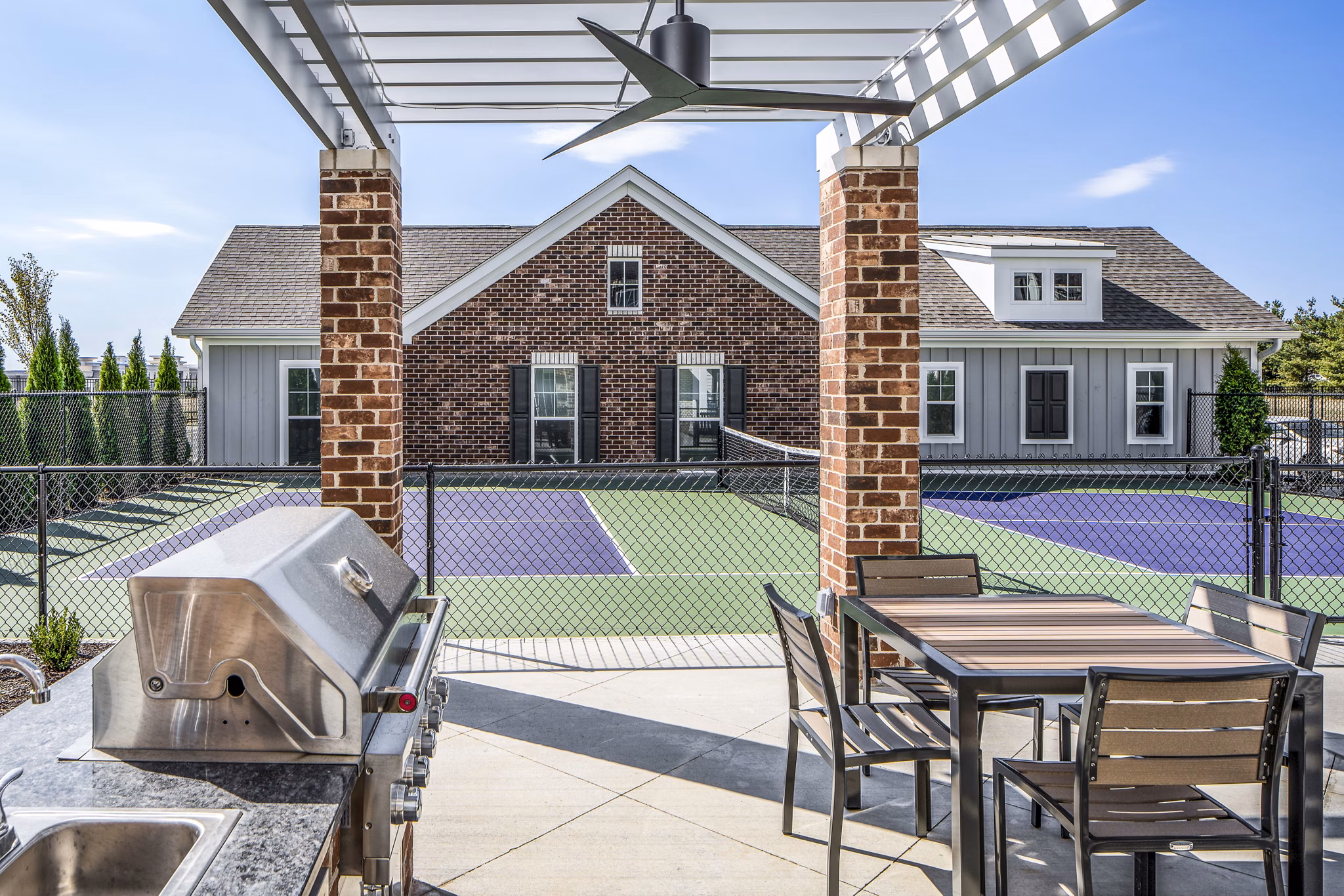 Outdoor grill area at Album Indian Lake Apartments featuring modern amenities for social gatherings and dining