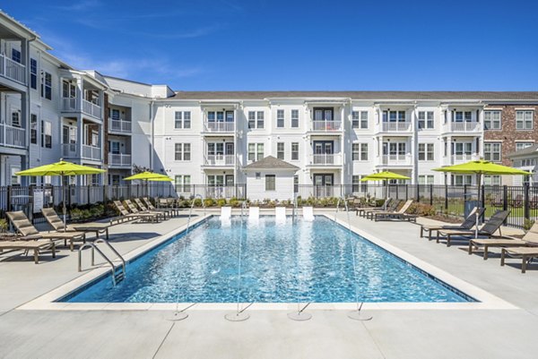 Resort-style pool area with sun loungers at Album Indian Lake Apartments