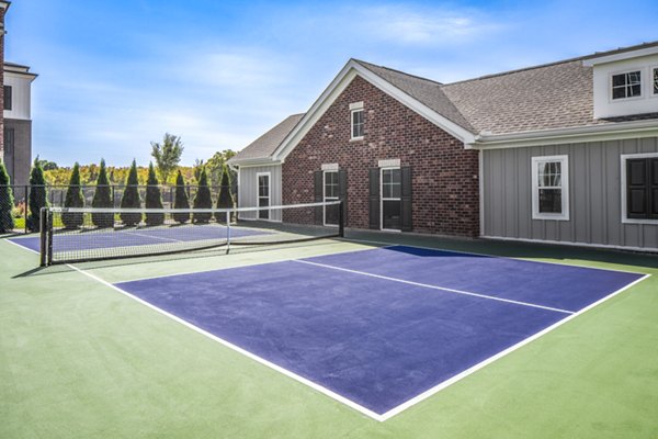 Outdoor tennis court surrounded by greenery at Album Indian Lake Apartments