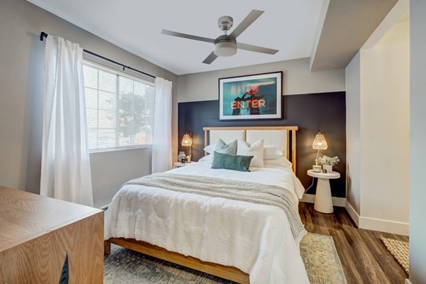 Bedroom with warm lighting and modern decor in Habitat at Fort Collins apartments