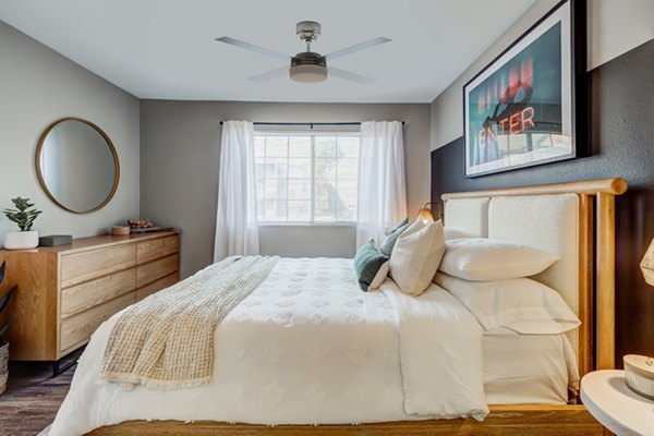 Bedroom featuring modern decor and large window in Habitat at Fort Collins apartments