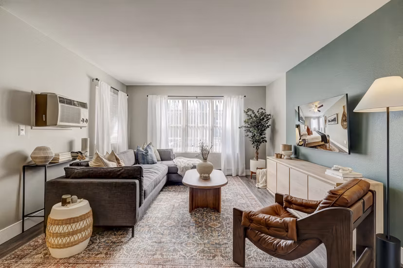 Cozy living room featuring modern furnishings and large windows in Habitat at Fort Collins apartments