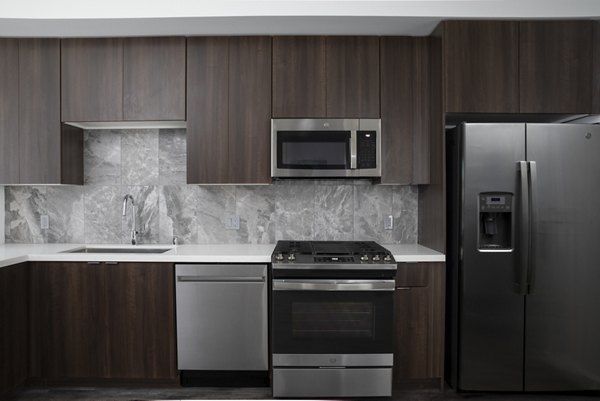Contemporary kitchen with stainless steel appliances in Vert Apartments