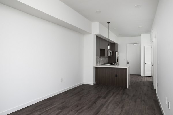 Living room with modern decor and large windows at Vert Apartments, luxury living by Greystar