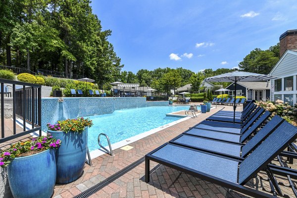 Relaxing outdoor pool with lounge chairs at Avana Powers Ferry Apartments, offering a luxurious amenity for residents