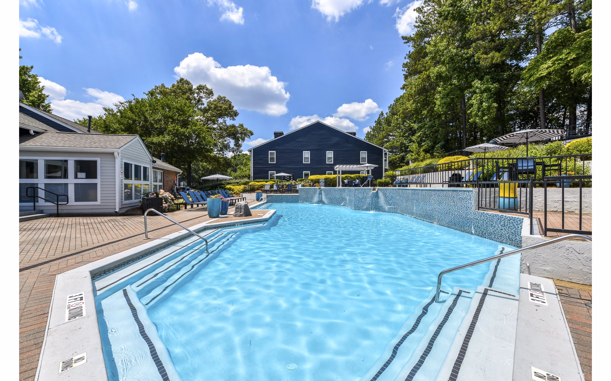Relaxing outdoor pool area at Avana Powers Ferry Apartments, featuring modern seating and lush landscaping
