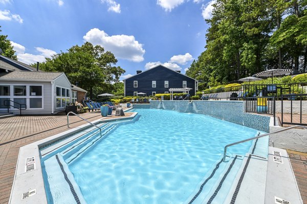 Relaxing outdoor pool area at Avana Powers Ferry Apartments, featuring modern seating and lush landscaping