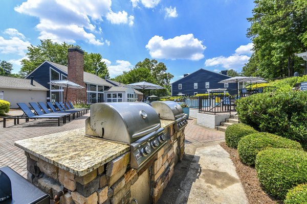 Outdoor grill area with modern seating at Avana Powers Ferry Apartments, perfect for social gatherings and enjoying the outdoor ambiance