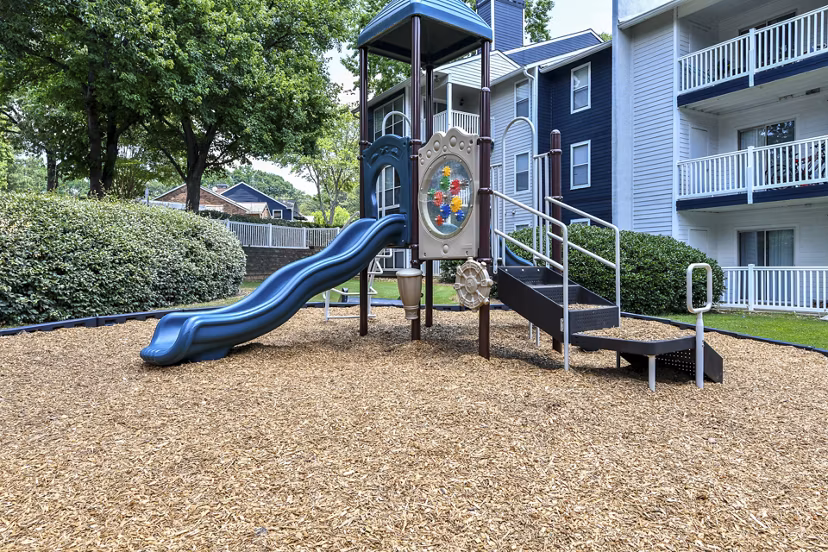 Accessible playground at Avana Powers Ferry Apartments offering slides and swings for family-friendly outdoor fun
