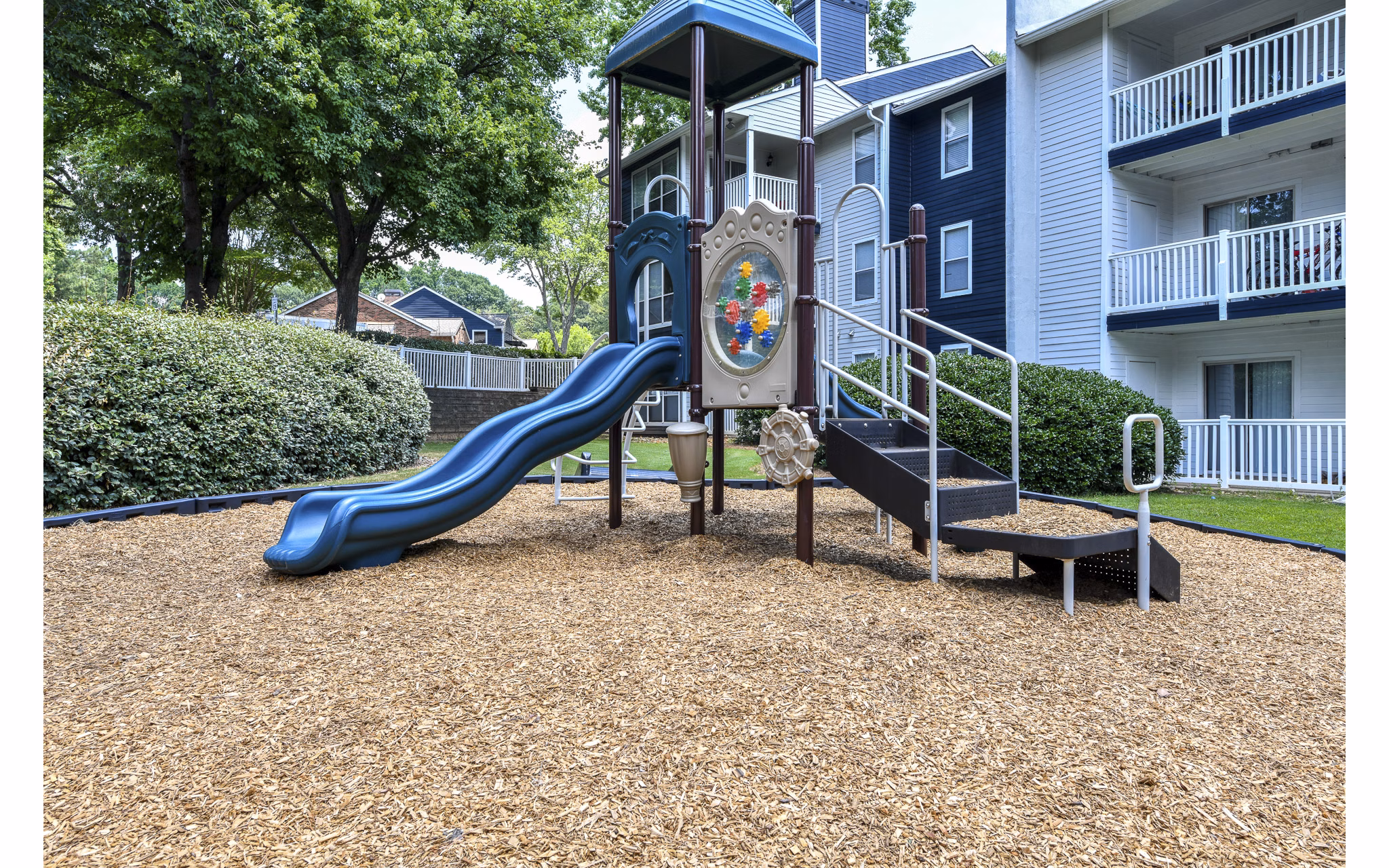 Accessible playground at Avana Powers Ferry Apartments offering slides and swings for family-friendly outdoor fun