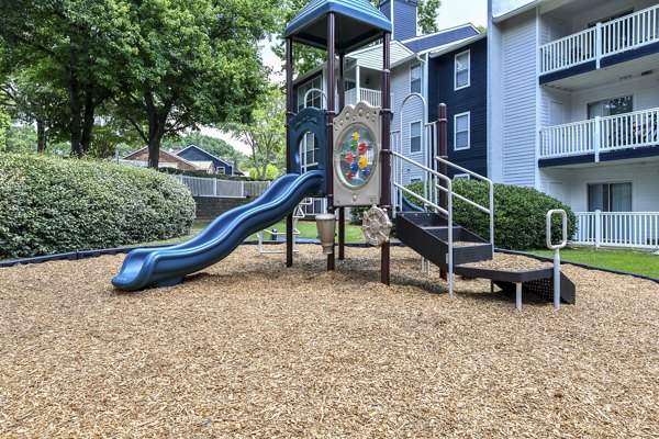 Accessible playground at Avana Powers Ferry Apartments offering slides and swings for family-friendly outdoor fun
