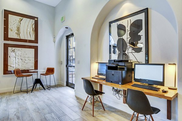 Modern business center with conference tables at The Alcove Apartments clubhouse