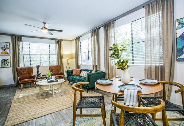 Dining room with modern furnishings and natural light at The Alcove Apartments, luxury living provided by Greystar
