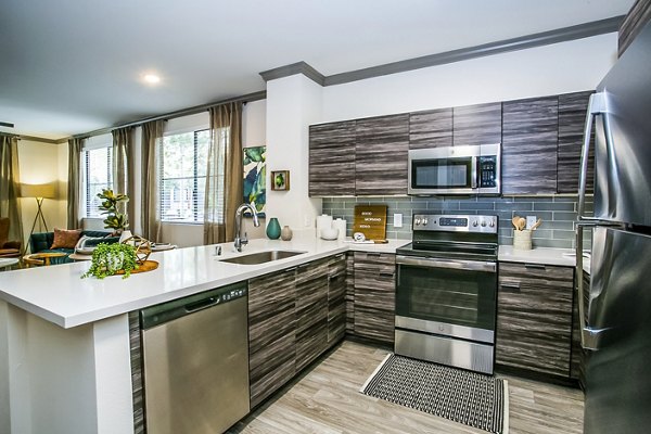 Modern kitchen with sleek countertops and stainless steel appliances at The Alcove Apartments, a luxury property by Greystar