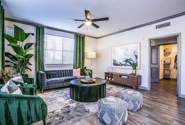 Spacious living room with modern decor and large windows in The Alcove Apartments, a luxury property by Greystar
