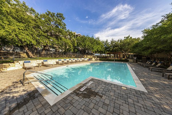 Spacious outdoor pool area with lounge chairs at The Highline Apartments, offering relaxation and leisure amenities for residents