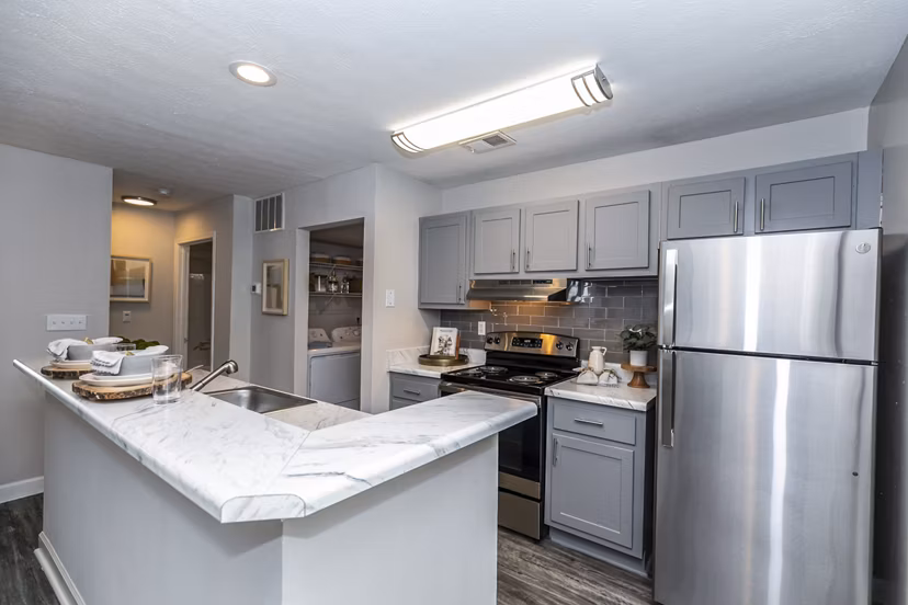 Modern kitchen with sleek countertops and stainless steel appliances in Champions Glen Apartments