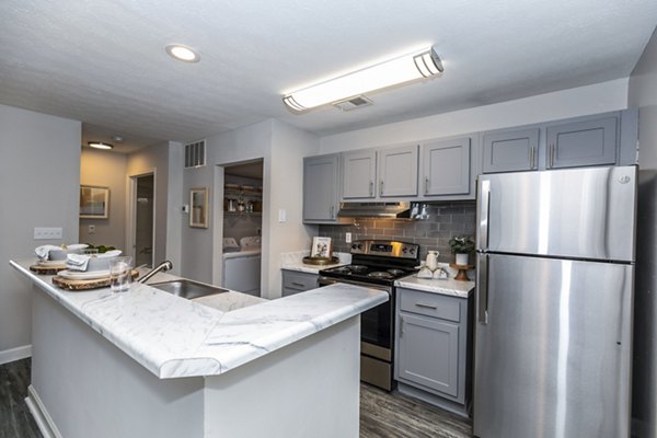 Modern kitchen with sleek countertops and stainless steel appliances in Champions Glen Apartments