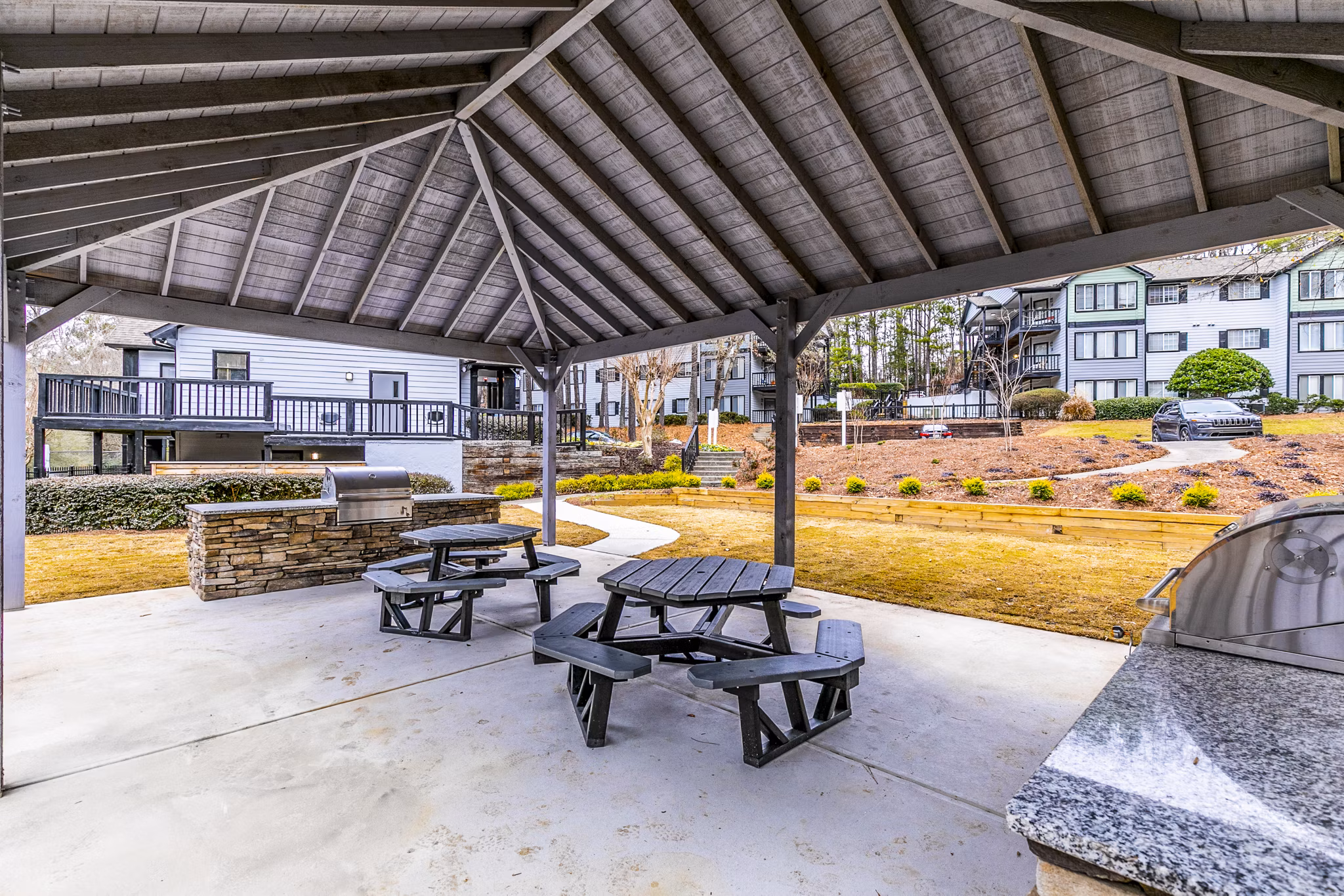 Grill area with seating at Champions Glen Apartments patio for outdoor cooking and dining