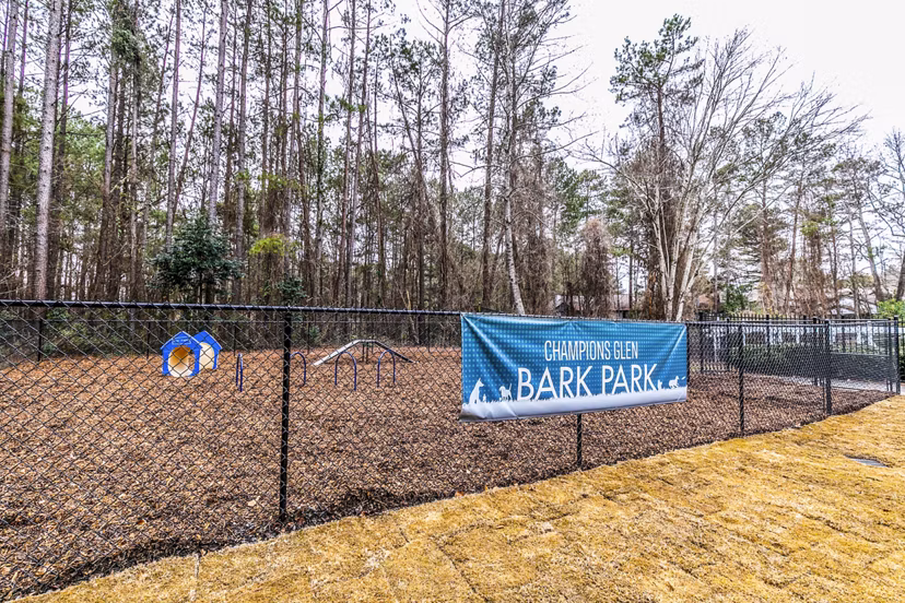 Dog park with agility equipment at Champions Glen Apartments, luxury pet-friendly community offering ample outdoor space for residents' pets