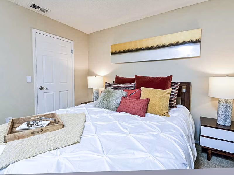 Cozy bedroom with stylish decor at Vineyard Gardens Apartments, luxury property with modern amenities and serene surroundings