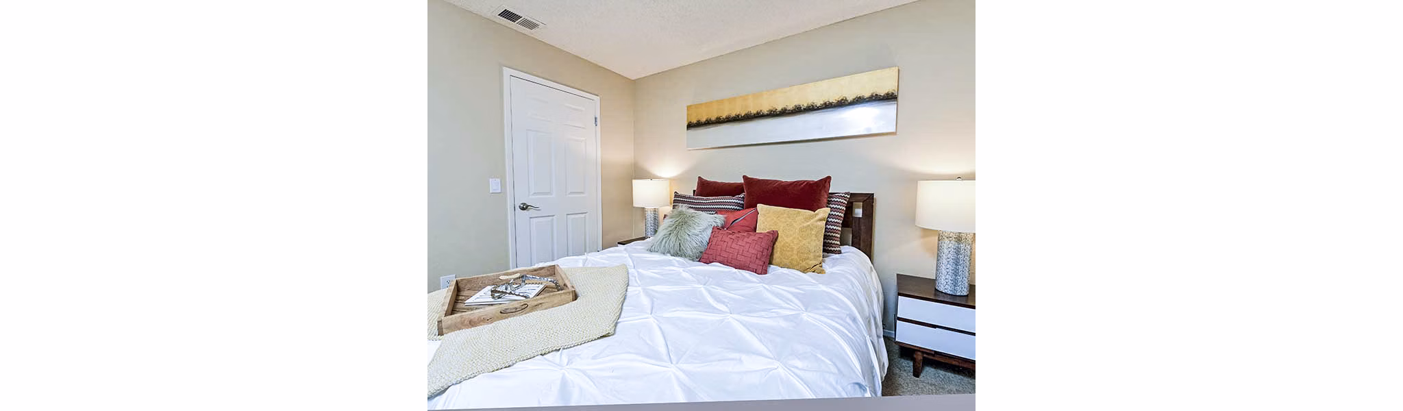 Cozy bedroom with stylish decor at Vineyard Gardens Apartments, luxury property with modern amenities and serene surroundings