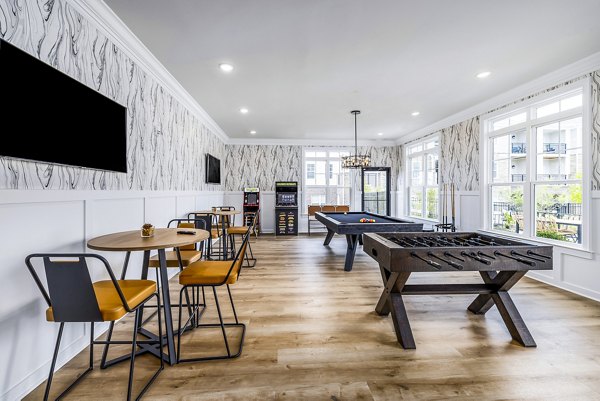 Clubhouse game room featuring billiards and lounge seating at River Oaks Landing Apartments