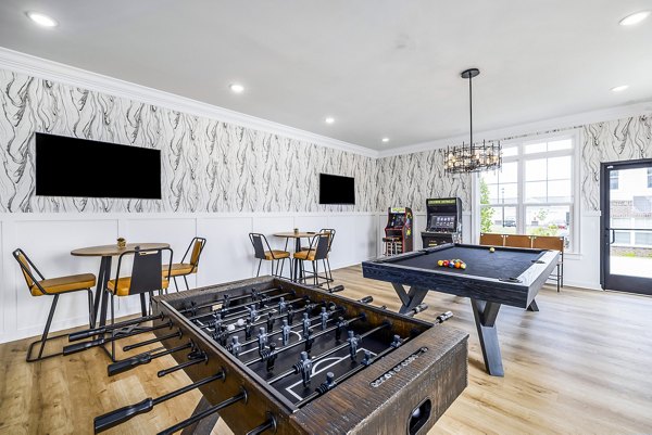 Clubhouse game room with pool tables and lounge seating at River Oaks Landing Apartments