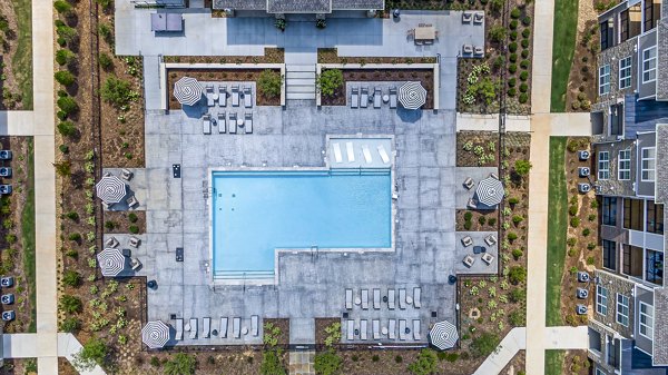 Riverside pool with lounge chairs at River Oaks Landing Apartments, perfect for relaxation and luxury living