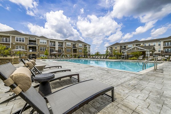Modern outdoor pool with lounge areas at River Oaks Landing Apartments