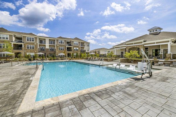 Riverside pool with lounge chairs at River Oaks Landing Apartments, perfect for relaxation and luxury living