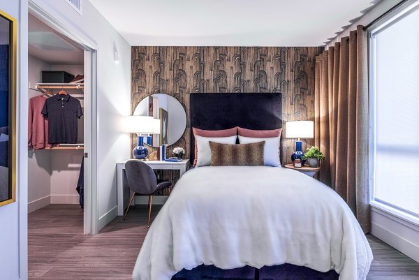 Bedroom featuring modern decor and plush bedding in Landsby Apartments