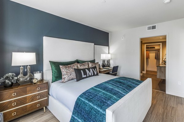 Bedroom featuring modern dÃ©cor and large windows at Landsby Apartments