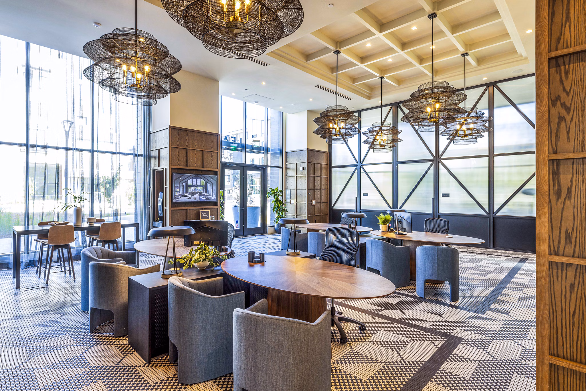 Landsby Apartments: Modern clubhouse lobby with stylish seating and expansive windows, creating a welcoming luxury apartment atmosphere
