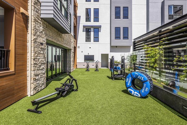Spacious fitness center with modern equipment at Landsby Apartments