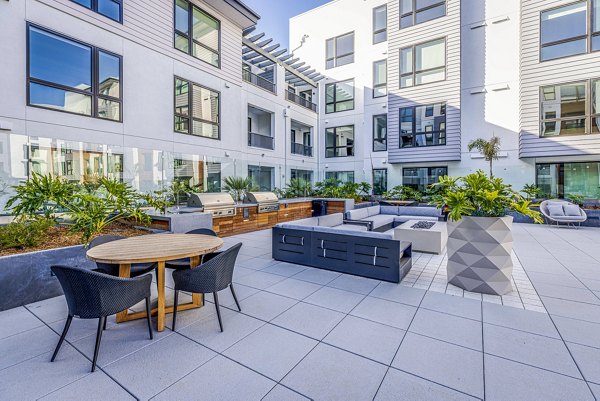 Patio with grills and seating area at Landsby Apartments, perfect for outdoor gatherings and leisure activities
