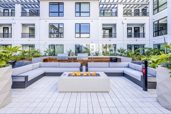 Cozy outdoor patio with fire pit at Landsby Apartments, perfect for relaxing evenings in a luxurious setting
