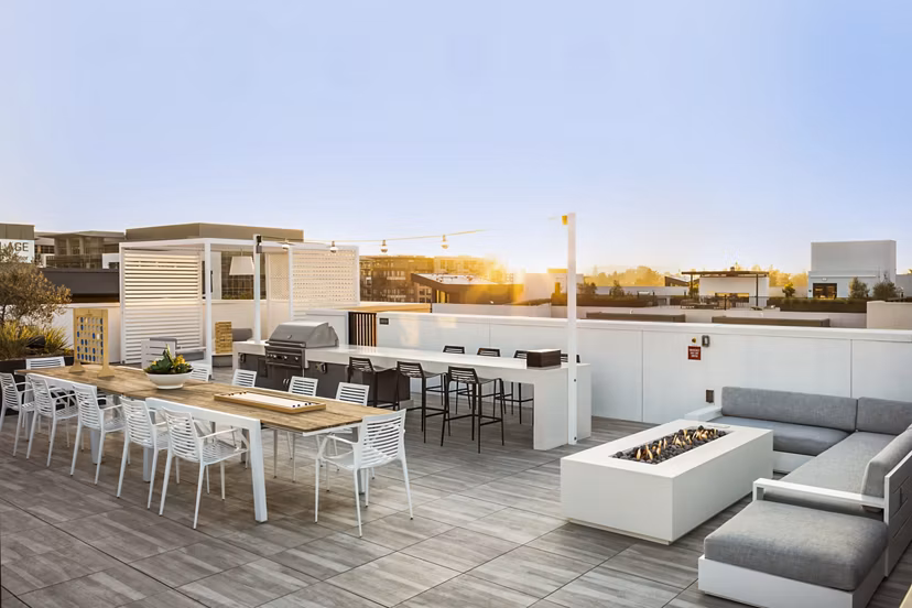 Outdoor grill area and fire pit at Landsby Apartments offering communal seating and landscaped surroundings for social gatherings