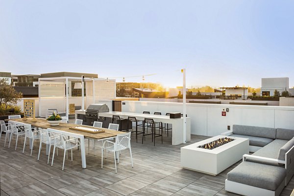 Outdoor grill area and fire pit at Landsby Apartments offering communal seating and landscaped surroundings for social gatherings