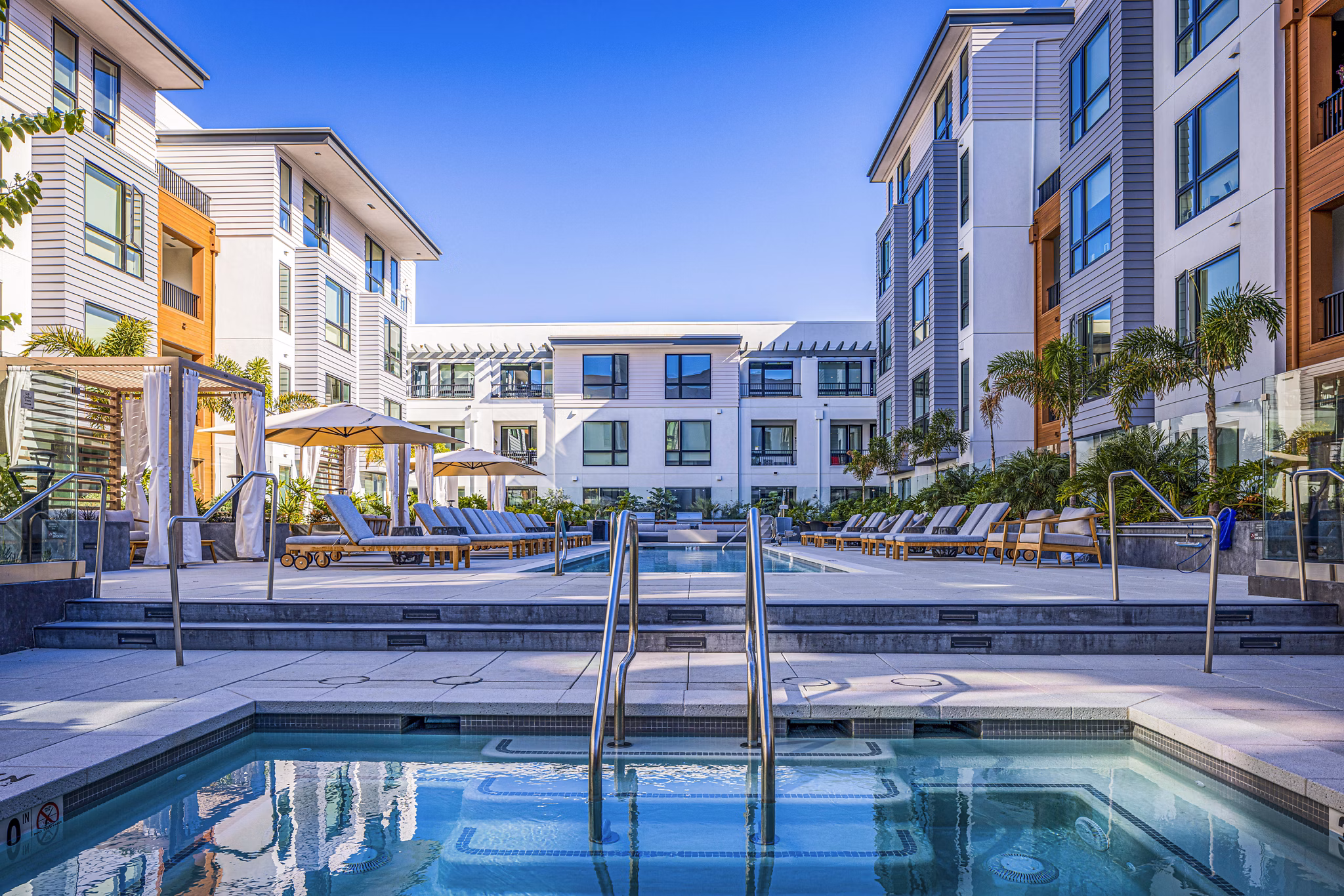 Inviting outdoor pool with lounge chairs at Landsby Apartments, ideal for relaxation and recreation