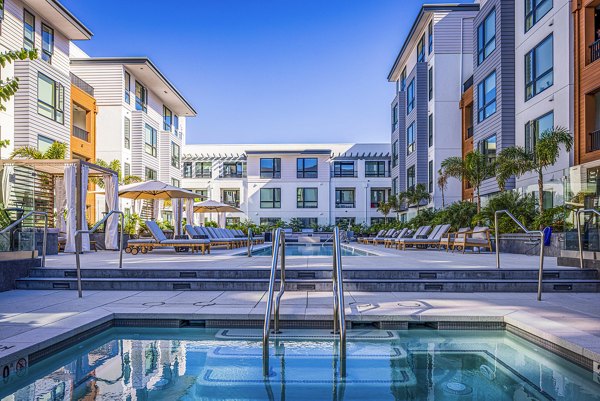Spacious pool area with lounge chairs at Landsby Apartments, offering luxury amenities for residents