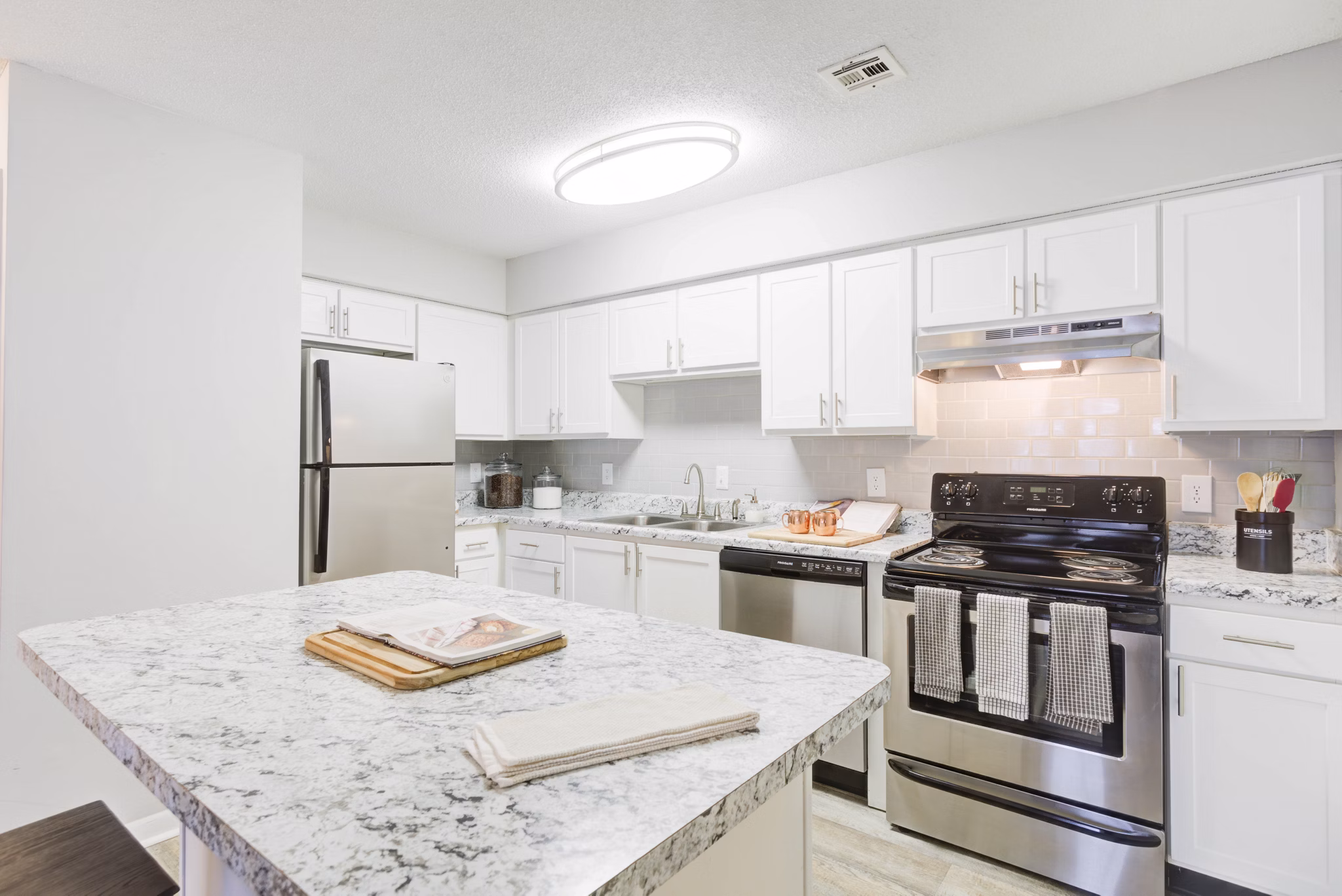 Modern kitchen with stainless steel appliances at Avana Collins Creek Apartments