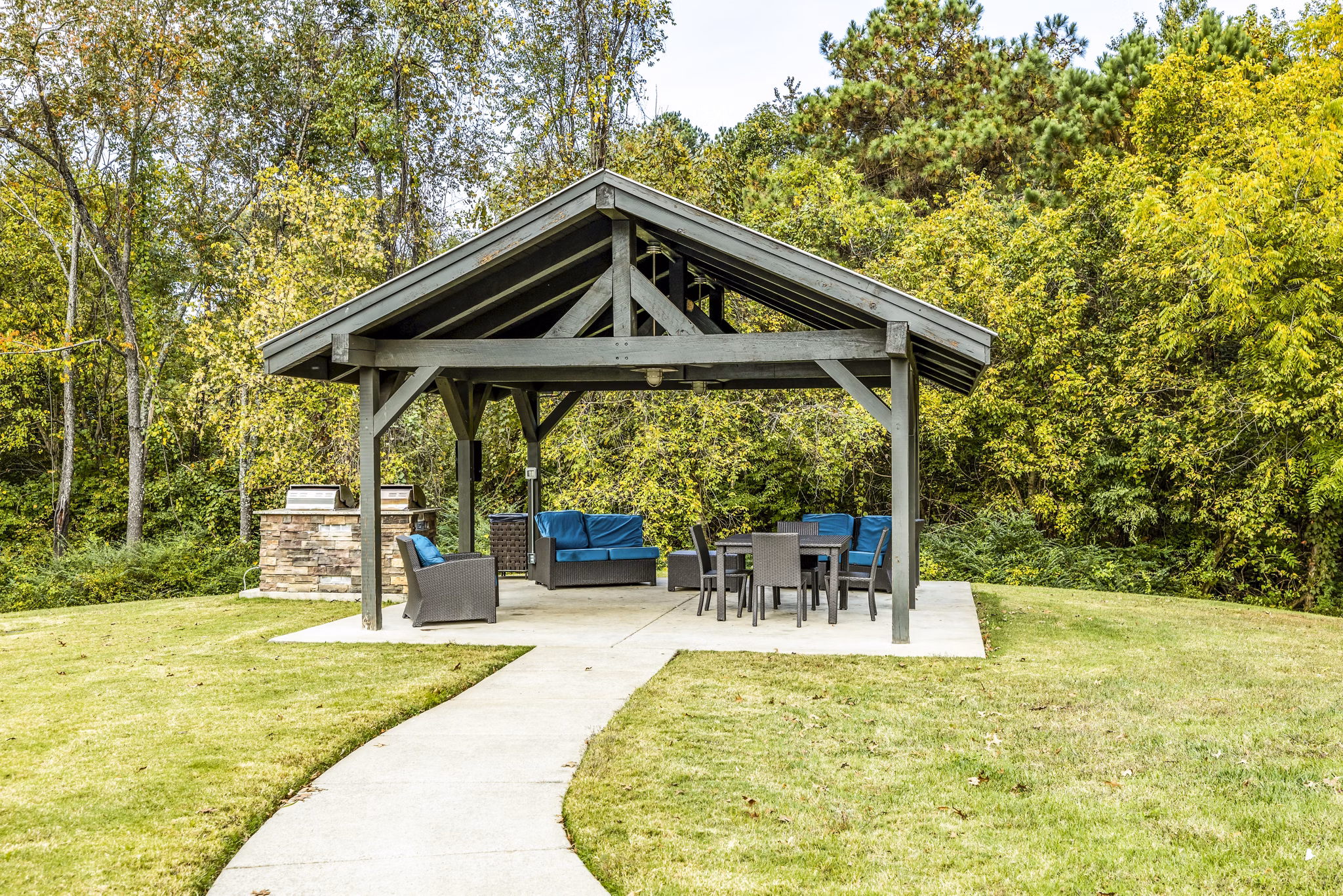 Outdoor grilling area with modern seating at Avana South Oaks Apartments, ideal for gatherings and leisure activities