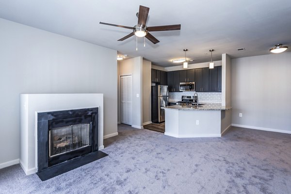 Living room with modern furnishings and large windows at Pinnacle at Town Center Apartments