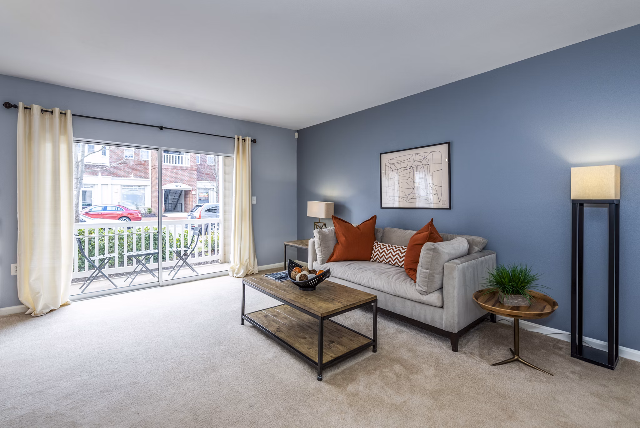 Contemporary living room with plush seating and natural light at Pinnacle at Town Center Apartments in Greystar community