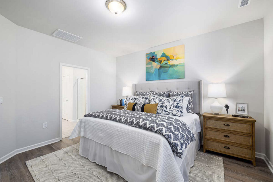 Cozy bedroom with modern decor at Ashford Townes Apartments, featuring plush bedding and ample natural light