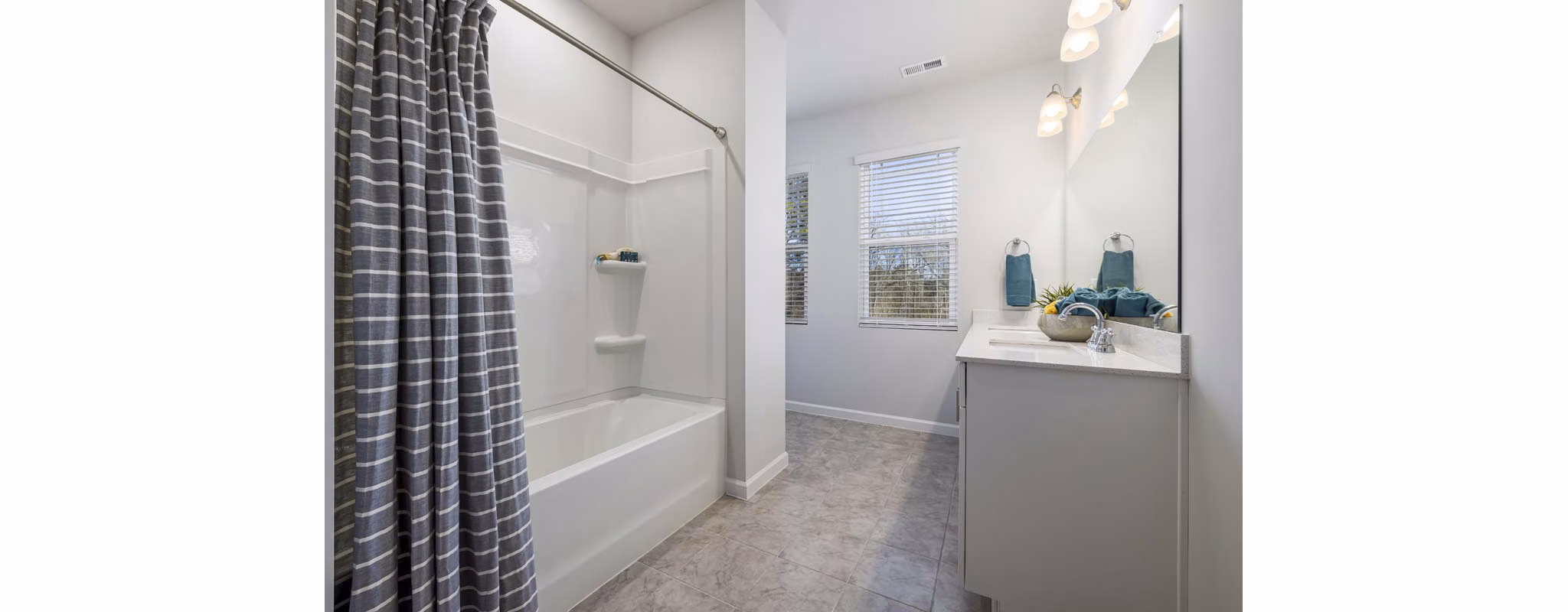 Modern bathroom with sleek fixtures and ample natural light at Ashford Townes Apartments, a Greystar luxury community