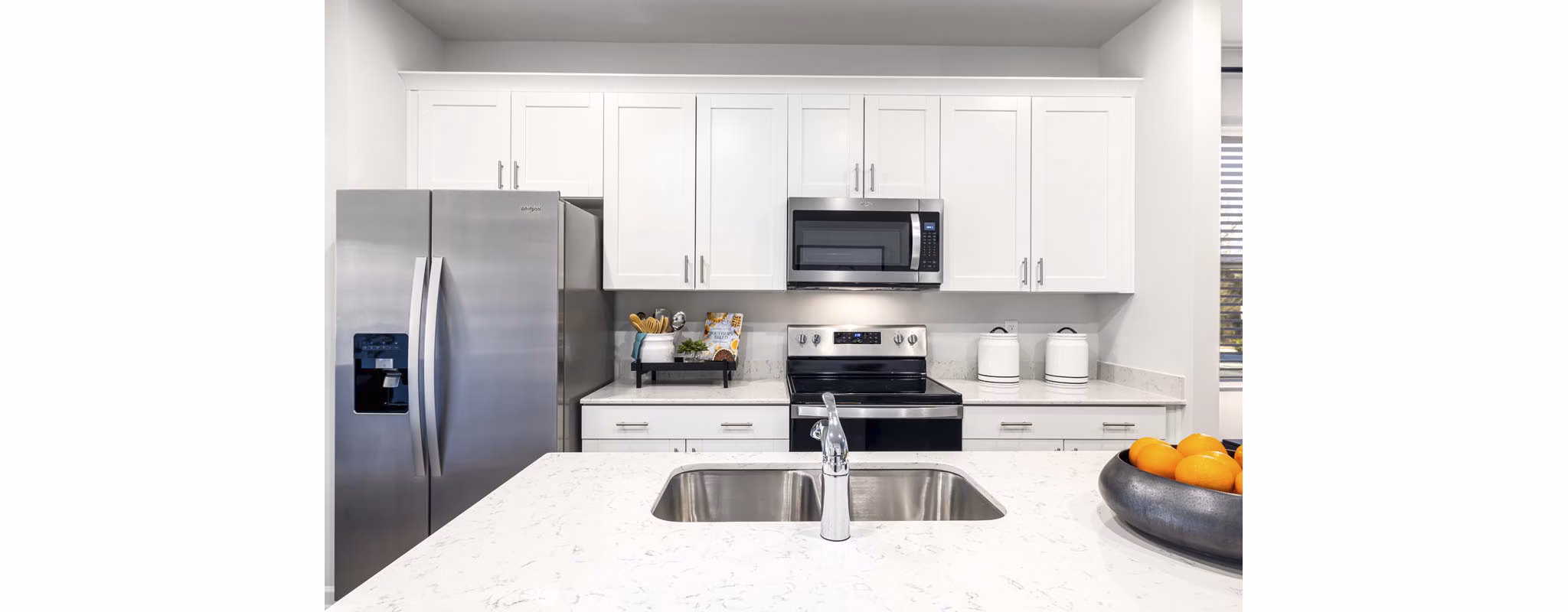 Modern kitchen with stainless steel appliances and granite countertops at Ashford Townes Apartments, Greystar luxury community